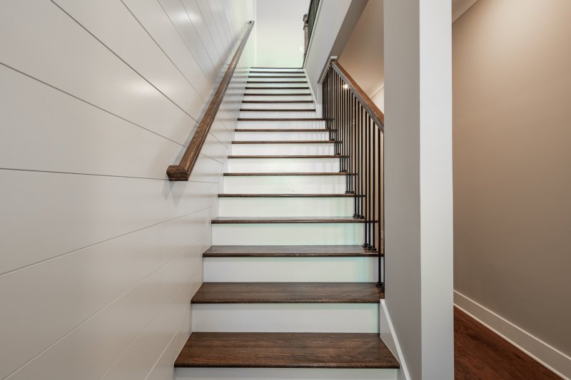 Brown and white staircase with white shiplap accent wall (Photo by KCULP - stock.adobe.com)