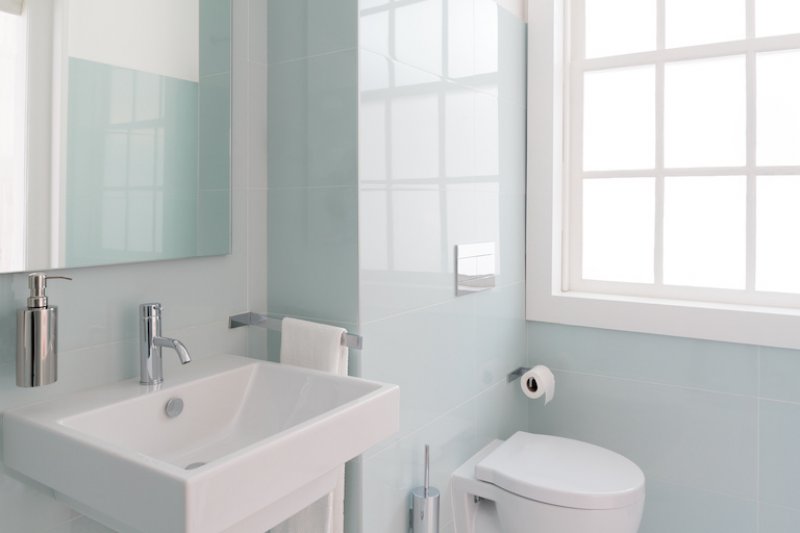 a white and mint green bathroom with modern fixtures (Photo by Diana Rui - stock.adobe.com)
