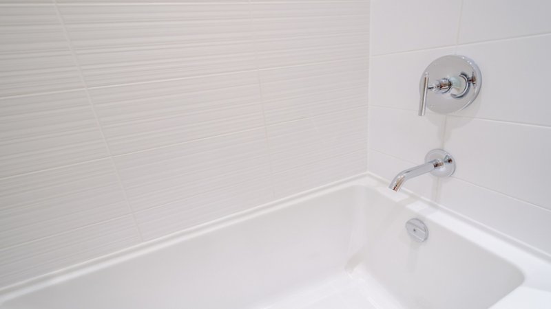 All white bathroom and tub (Photo by ppa / Shutterstock.com)