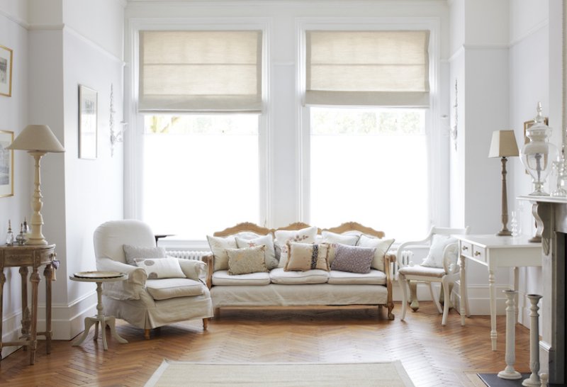 large white room with white walls and furniture, wood floors, and large, bright windows (Photo by Newton Daly/DigitalVision via Getty Images)