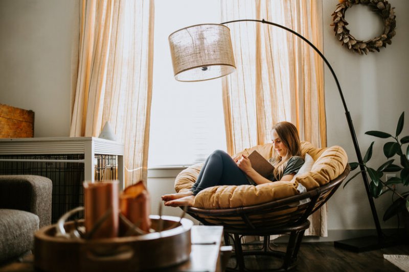 Woman reading indoors in rattan chair (Photo by MeganBetteridge - stock.adobe.com)
