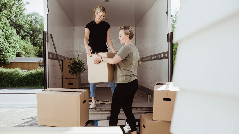 Women unload boxes from moving van (Photo by Maskot via Getty Images)