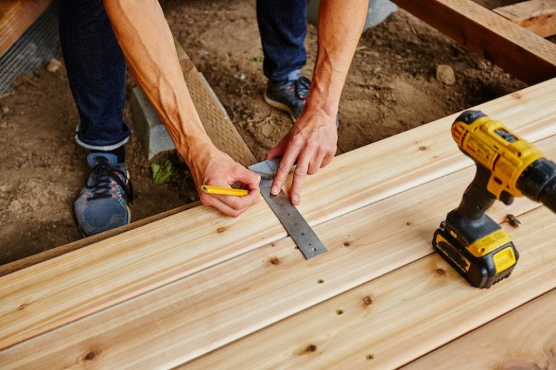 a man drilling wood for a new deck (Photo by © maxwellmonty - stock.adobe.com)