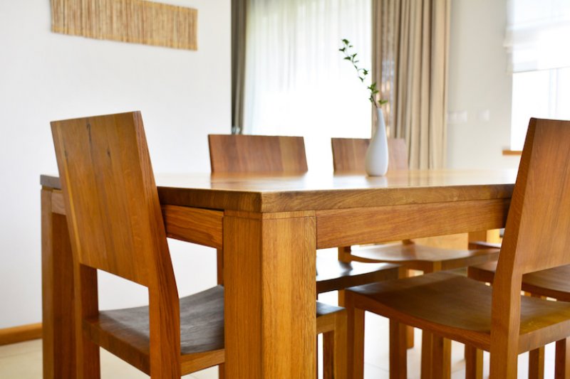closeup view of medium wood dining table and chairs (Photo by CharMoment - stock.adobe.com)