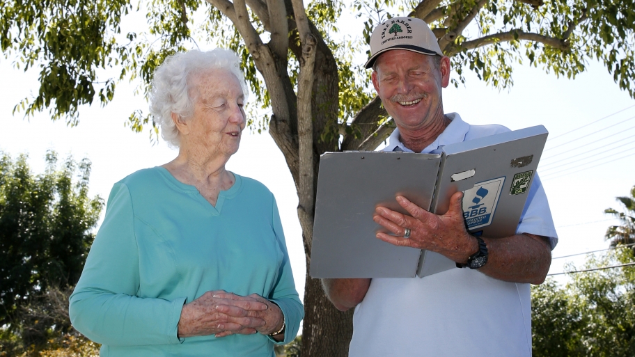 customer and contractor standing in front of tree