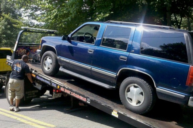 large SUV being hooked onto a tow truck