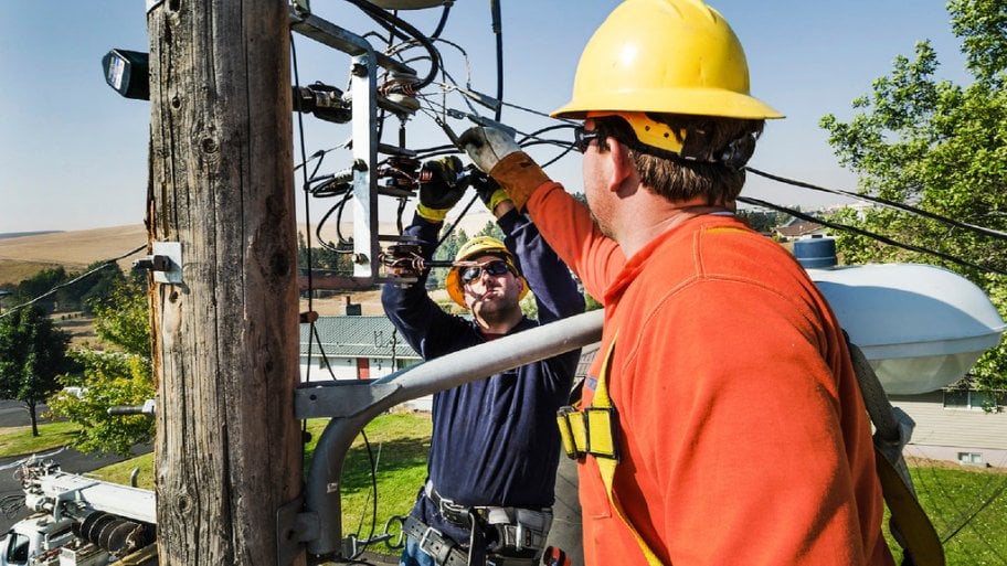 Power line workers working on utility pole