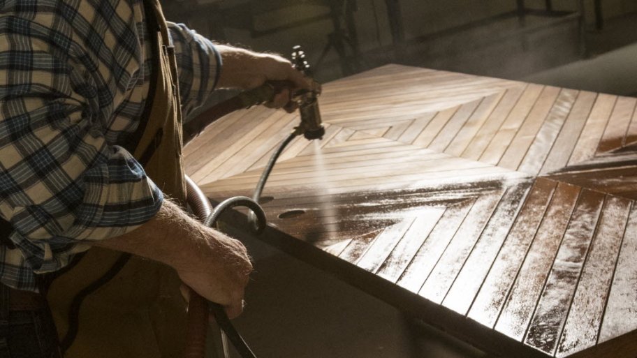 Greg Doublestein of The Front Gate sprays a coat on varnish on a door