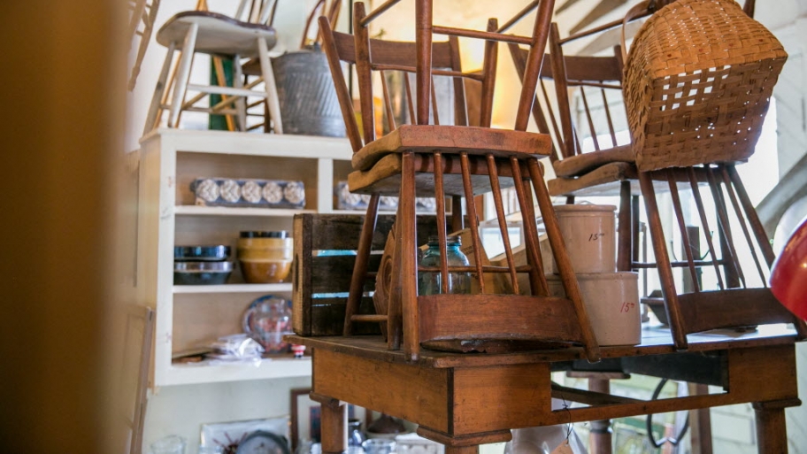 some wooden antique chairs stacked on a table