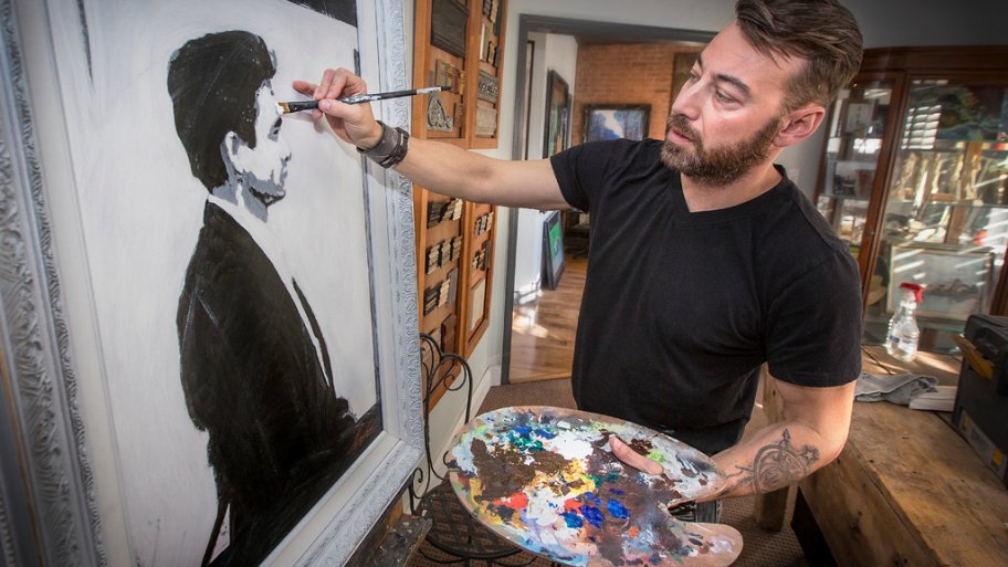 Silver Crow Studios' Sean Sheppard completes a painting of Johnny Cash.