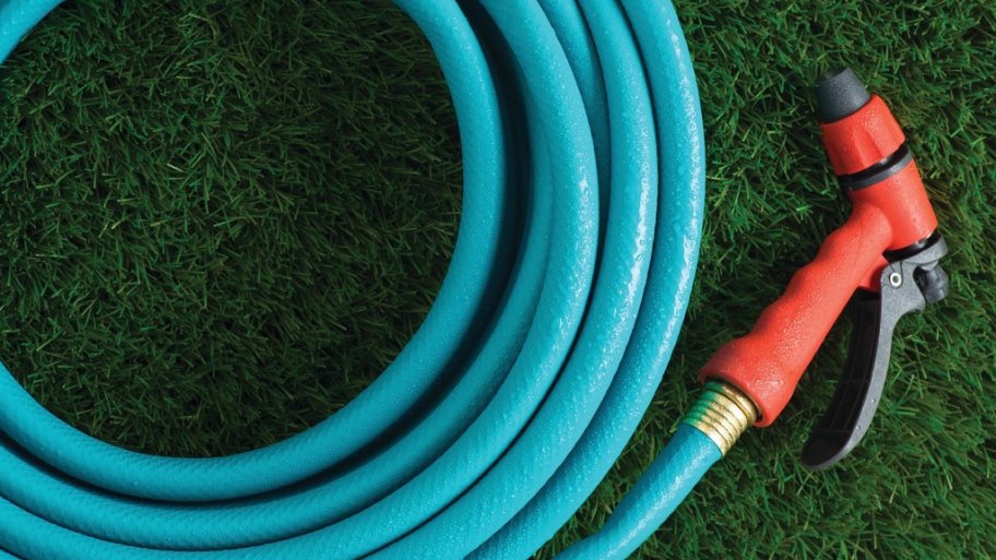 a blue garden hose and sprayer laying on grass