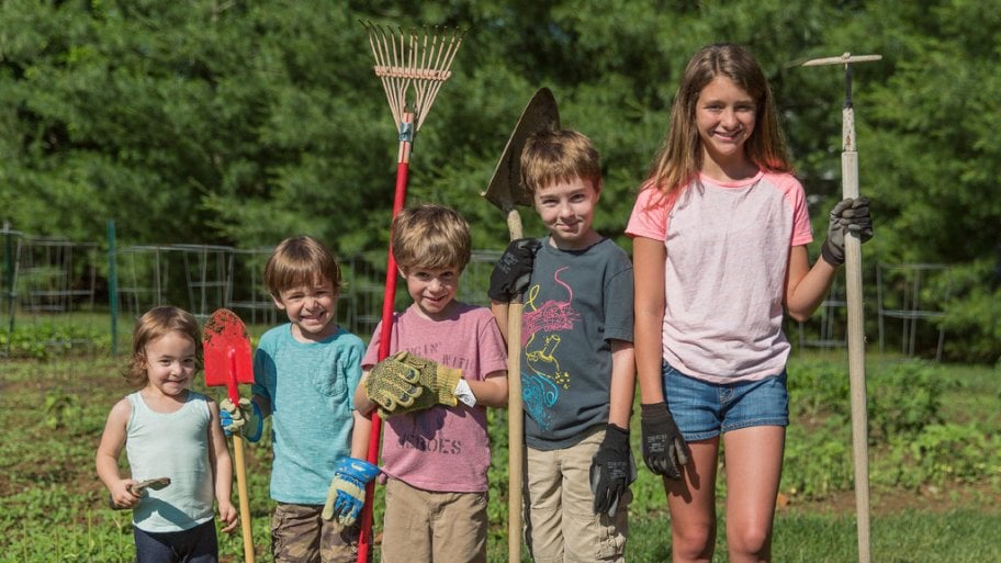 Five children, from youngest to oldest going left to right, all with garden tools