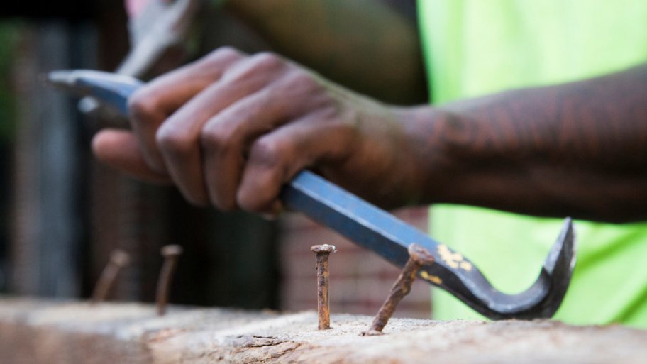Worker at Southern Pine Co. in Savannah, Georgia removes nails from reclaimed wood
