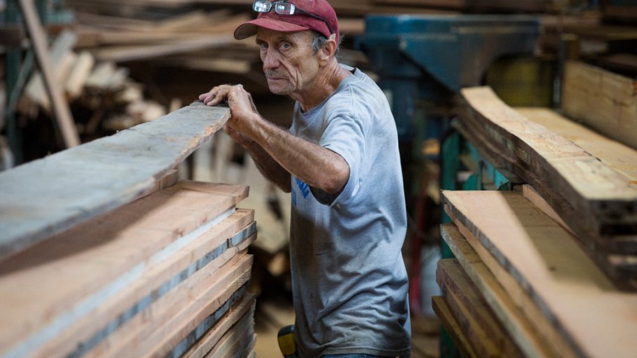Carpenter surveys reclaimed wood at Southern Pine Co. warehouse in Savannah, Georgia