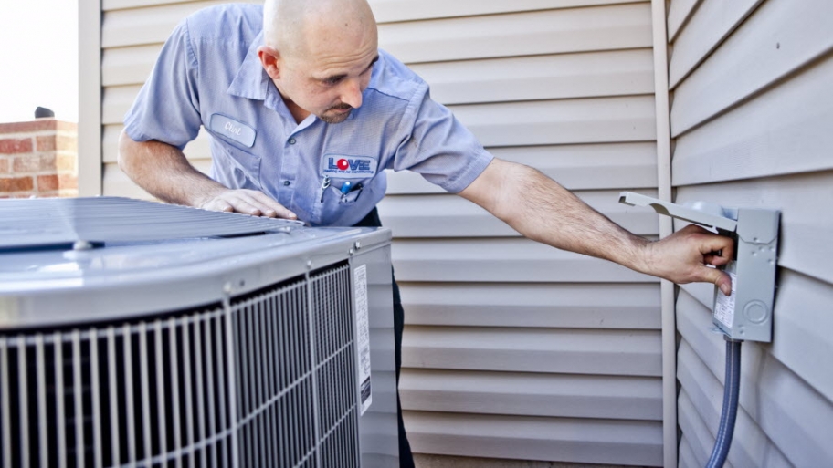 HVAC worker inspecting an outdoor A/C unit