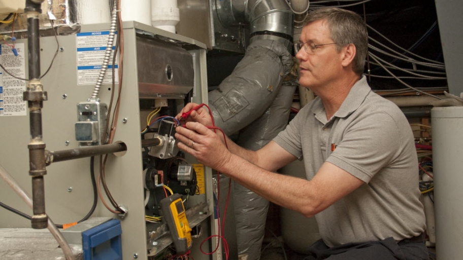 HVAC maintenance technician working on a unit