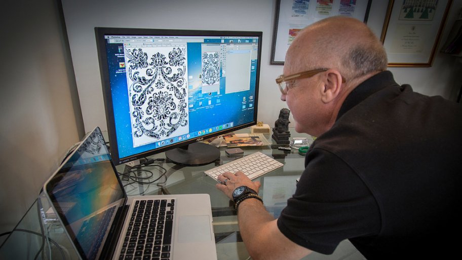 Walter Knabe looking a one of his wallpaper designs on computer