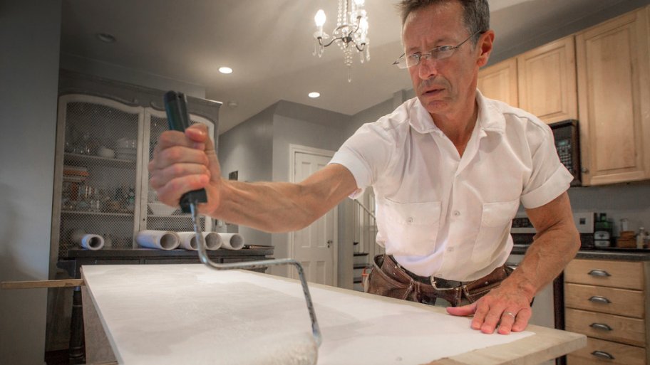 Wallpaper hanger Jim Stocking pasting a Walter Knabe design before hanging on the ceiling