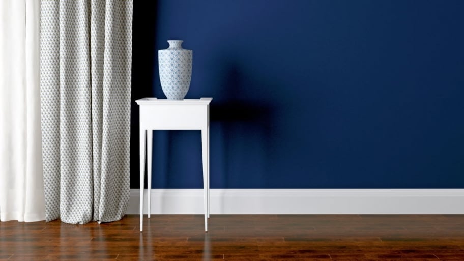 Blue wall, white baseboard in room setting