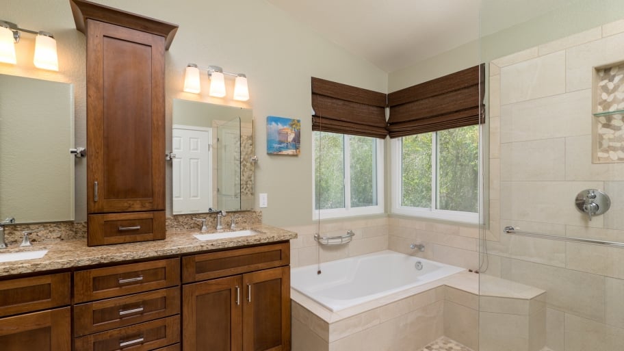 remodeled bathroom with cabinets, tile and tub