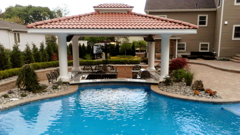 A pool with a cabana in the background