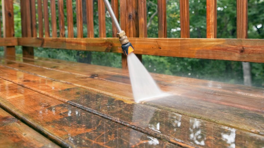 pressure washing pressure washer spraying wood deck