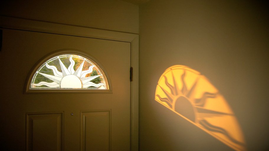 decorative window film shaped as a sun on peephole window of entry door