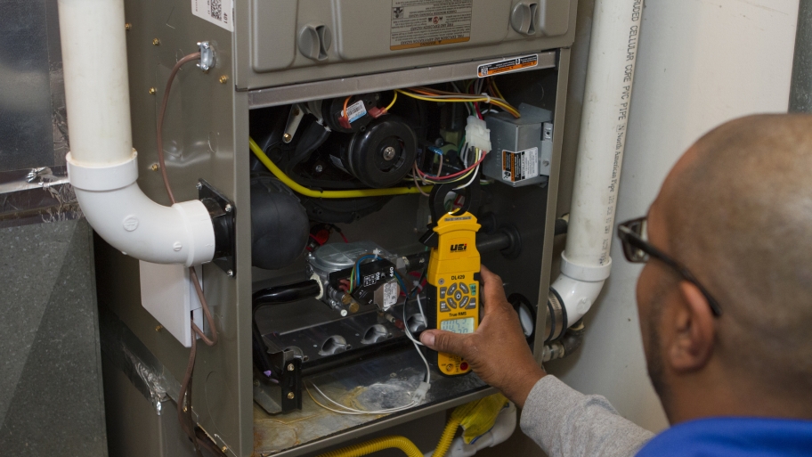 furnace technician performs HVAC repairs