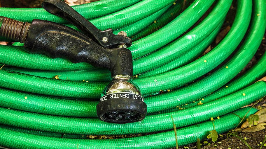 green garden hose and spray nozzle