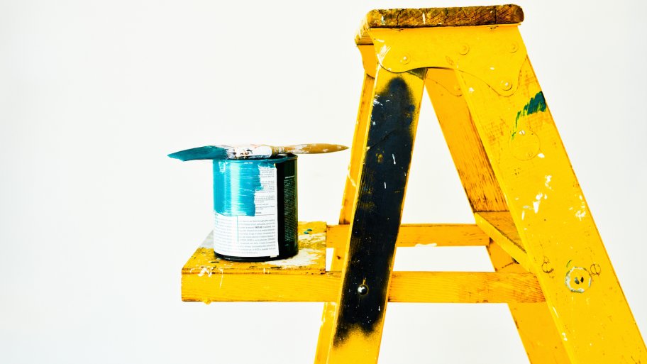 yellow ladder with paint and paintbrush