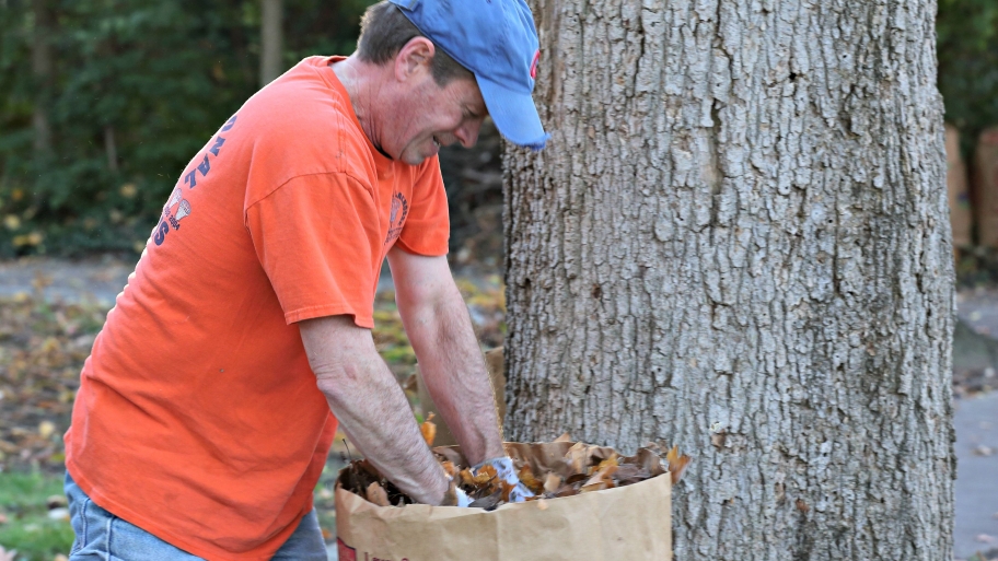 man picking up leaves