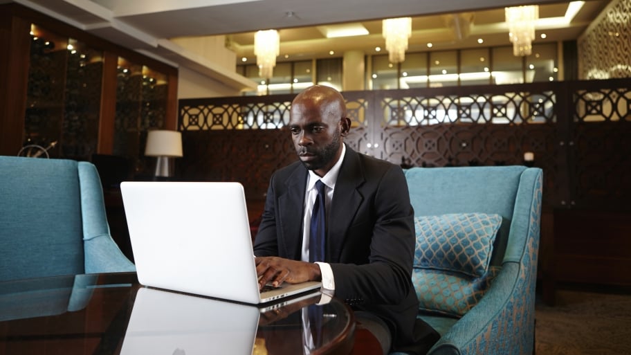 man on computer in hotel lobby