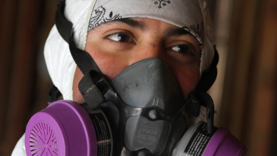 a mold removal specialist in a breathing mask.