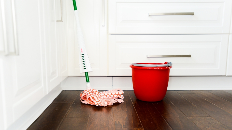 mop and red bucket on wood floor