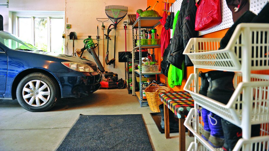 blue car in garage with lawn mower pegboard and shelves
