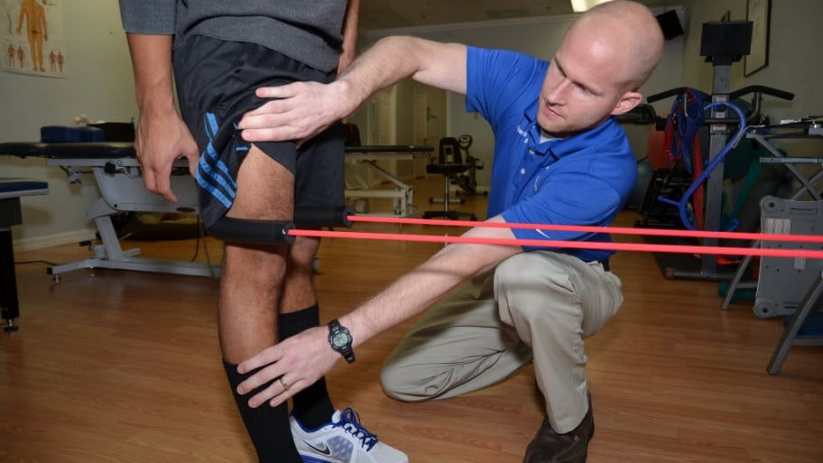 A physical therapist stretches a leg