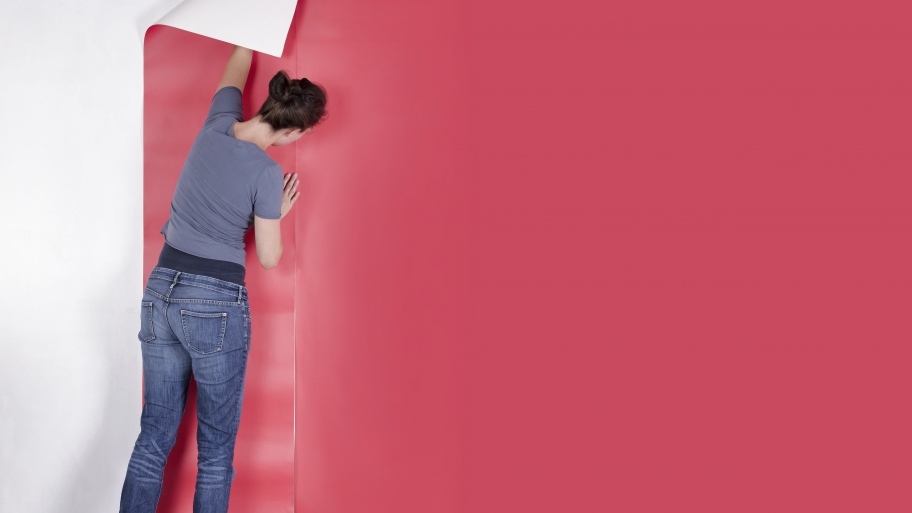 woman applying pink wallpaper