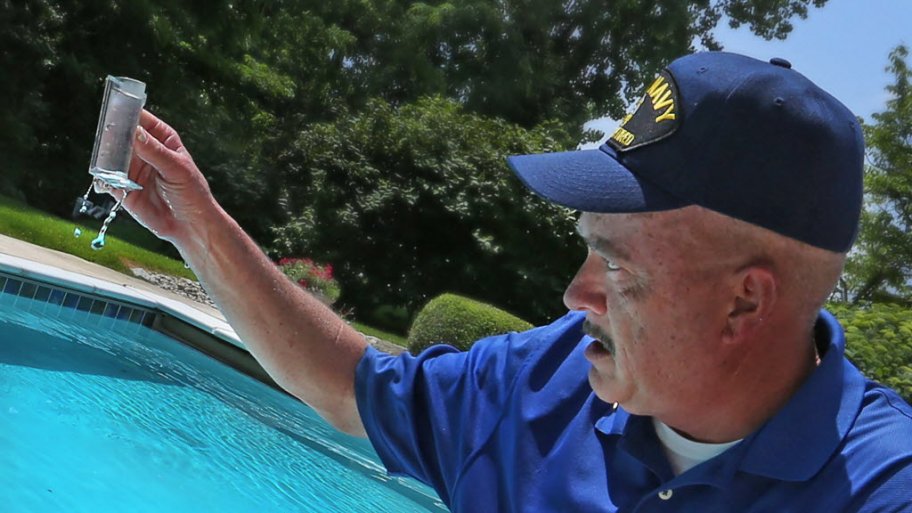 A pool cleaner checks chemicals