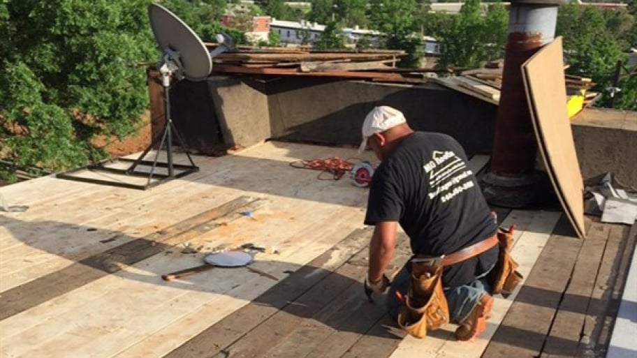 Roofer working on flat roof repair