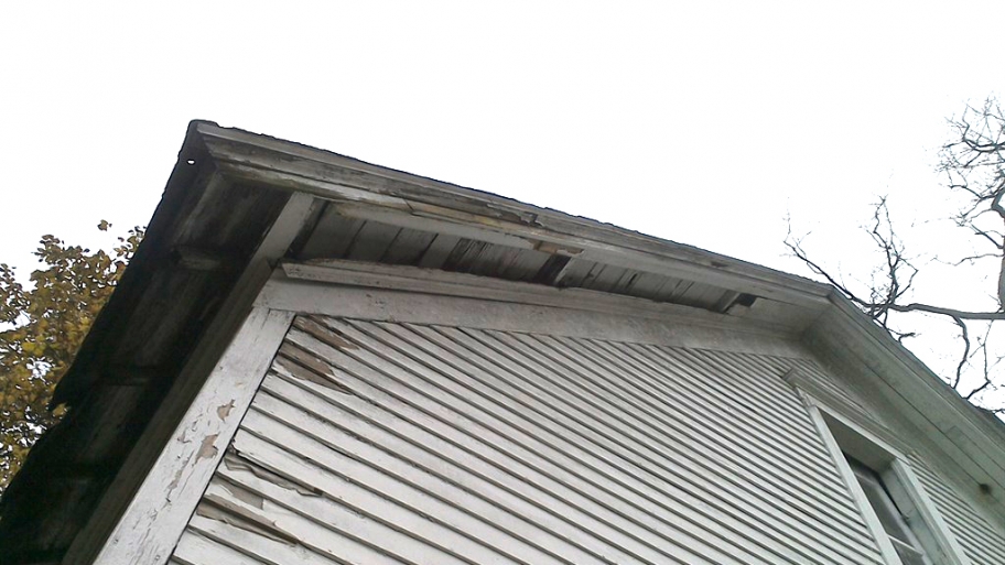 Rotten soffit and old roofing on shed