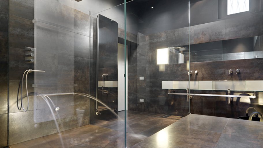 Stone shower with multiple shower heads and chrome hardware