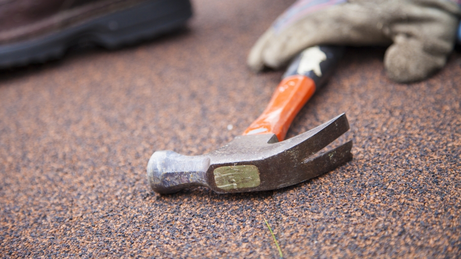 contractor with hammer on roof