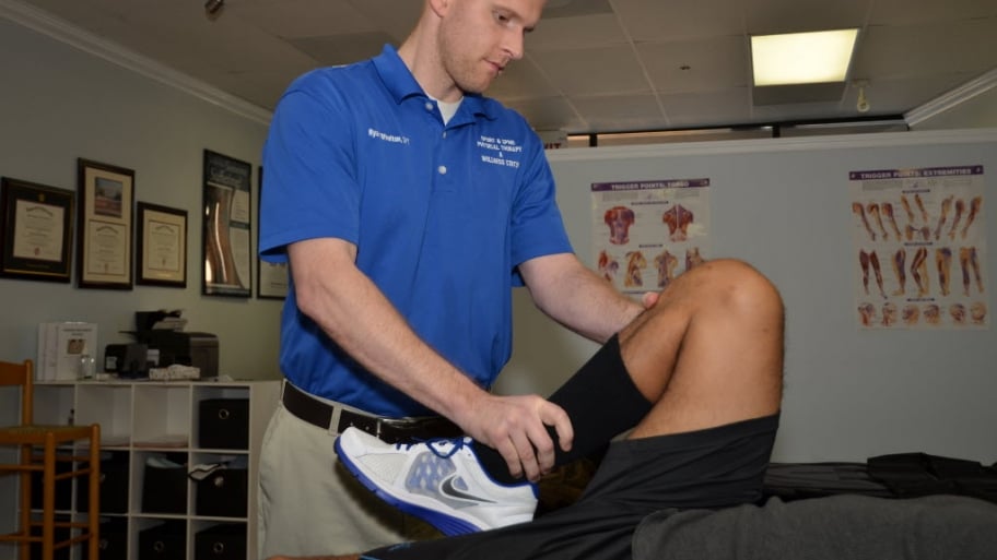 A physical therapist stretches a leg