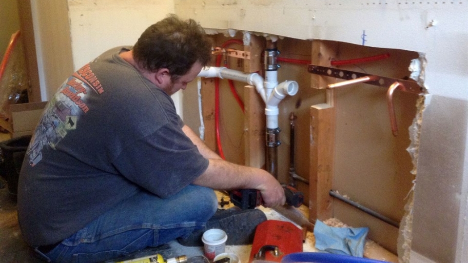 plumber working on kitchen remodeling project
