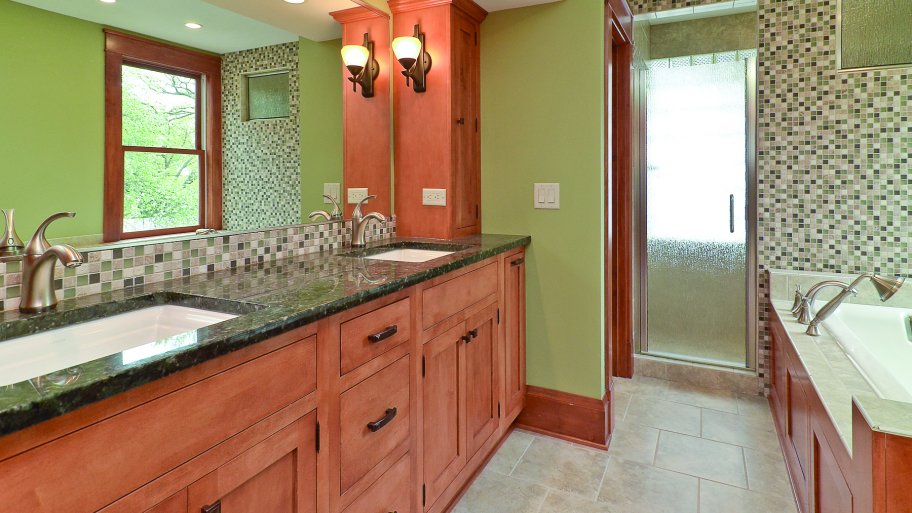 bathroom with brown cabinets and mosaic tile backsplash.