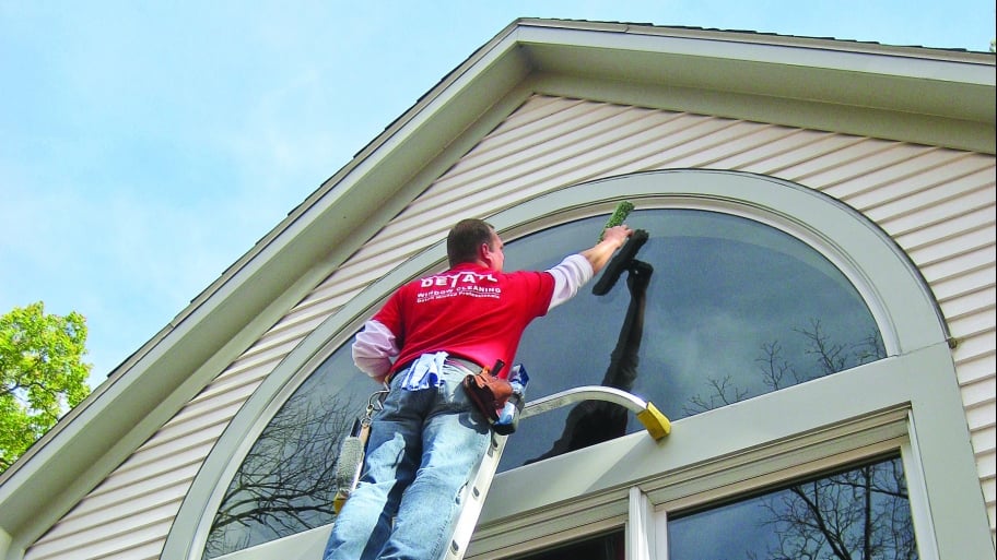 clean windows, window cleaning man on ladder washing exterior windows on house