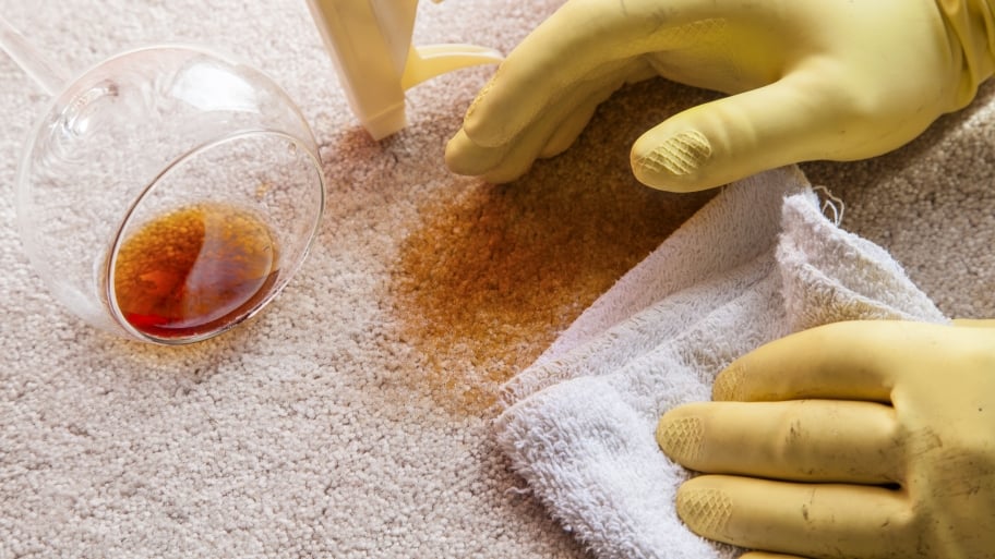 gloved hands cleaning wine stain