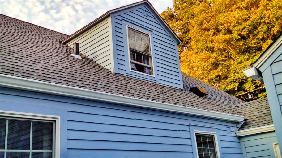 blue house with asphalt roof shingles
