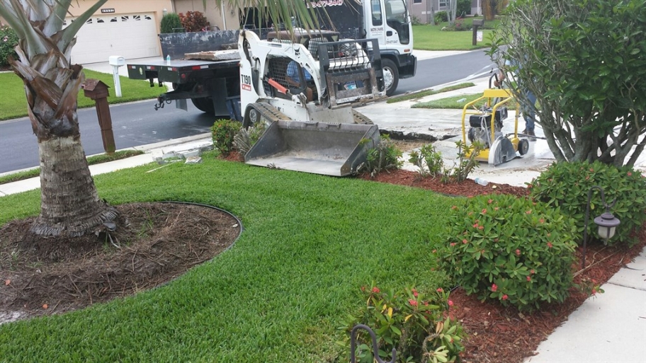 Workers removing a concrete driveway