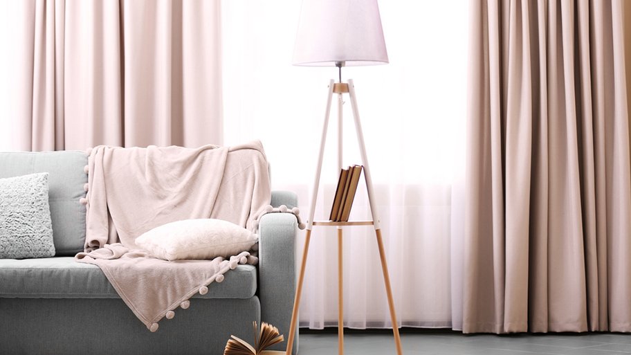 sun blocking curtains next to couch, table and lamp